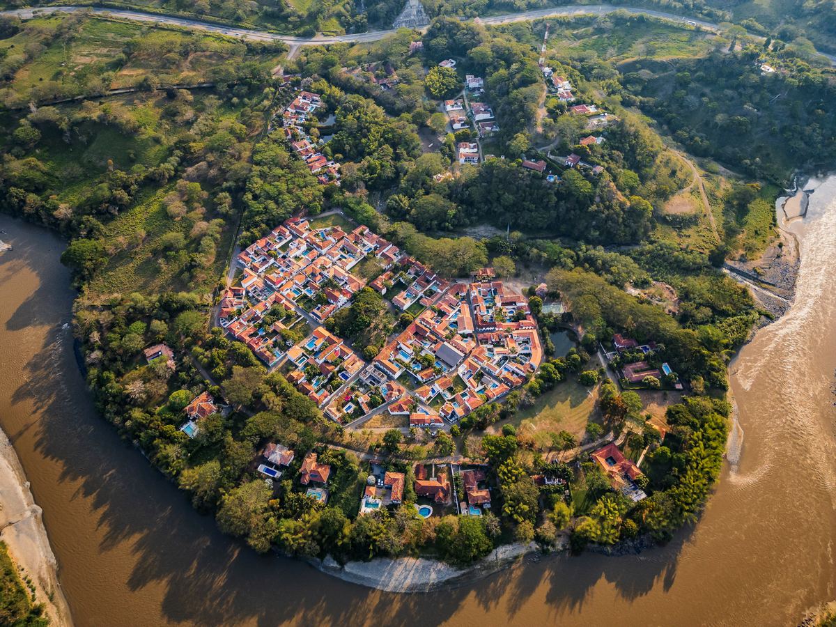 Los tejados de barro y las casas blancas de Cauca Viejo desde el aire, rodeados de árboles