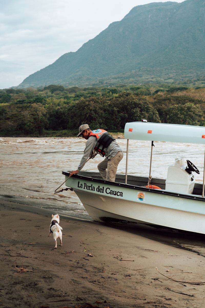 El lanchero tira de la cuerda para acercar la lancha a la playa del río